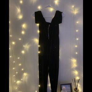 Black off the shoulder jumpsuit with side pockets and sliver zipper